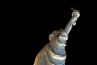 Low angle view of statue against black background