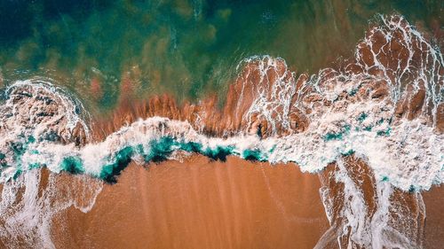 High angle view of surf on sea shore