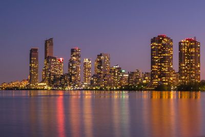 Illuminated buildings against sky at night