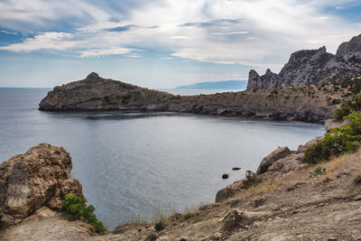 Rock formations by sea against sky