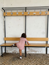 Rear view of girl climbing a bench 