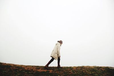 Man standing on field against clear sky