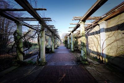 Empty footpath amidst buildings against clear sky