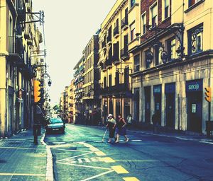 People on street in city against sky