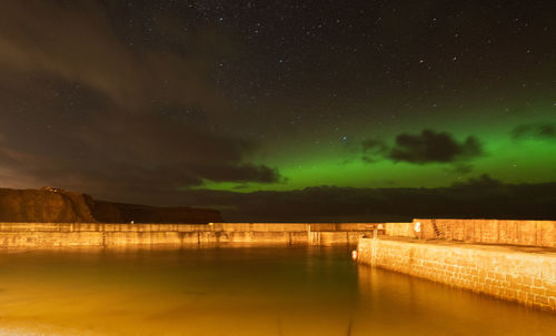 Scenic view of lake against sky at night