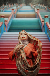 Beautiful woman wearing scarf while standing on steps