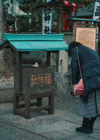 Rear view of woman bowing and praying