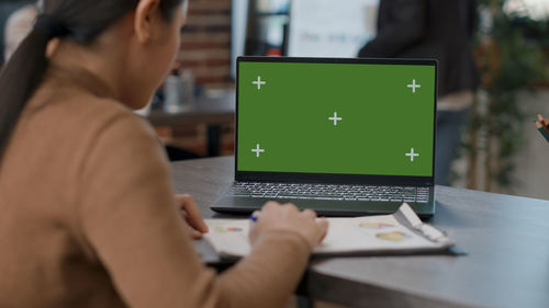 Side view of man using laptop at office