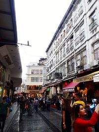 People on street amidst buildings in city