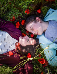 High angle view of sisters relaxing on grass