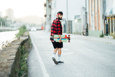 Man with umbrella on road in city