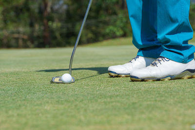 Low section of person relaxing on golf ball