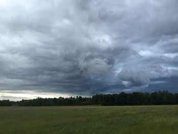 Scenic view of grassy field against cloudy sky