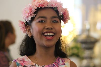 Portrait of smiling girl wearing flowers at home