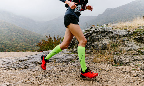 Low section of woman walking on mountain