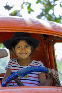 Portrait of smiling girl sitting outdoors