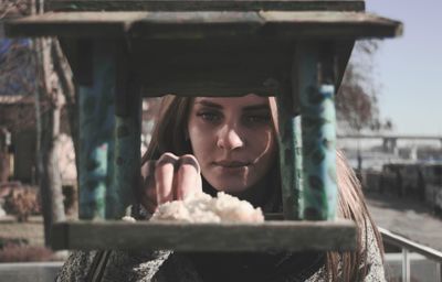 Portrait of a beautiful young woman holding window