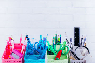 Close-up of multi colored pencils on table against wall