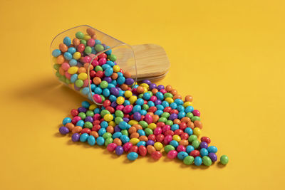 Colorful chocolate candy's, sugar coated chocolate gems candy on colorful background.