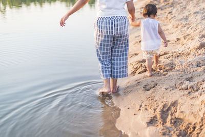 Mother and daughter walking on the beach.