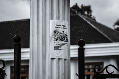 Close-up of sign on pole against built structure