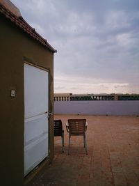 Chair on beach against sky