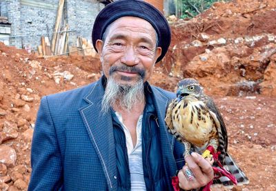 Portrait of young man holding bird