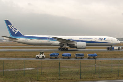 Airplane on airport runway against sky