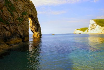 Rock formation in sea against sky