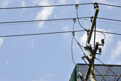 Low angle view of electricity pylon against sky