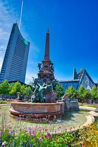 Fountain and building against blue sky