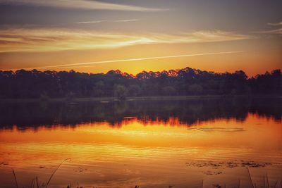 Scenic view of lake against orange sky