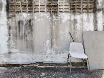 Empty chair against wall