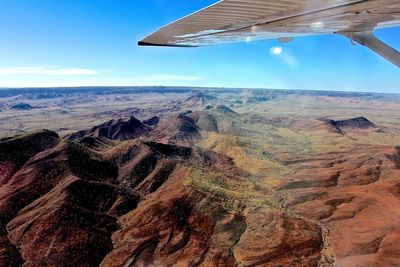 Cropped image of airplane over purnululu national park against blue sky