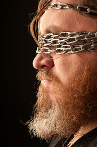 Portrait of man wearing mask against black background