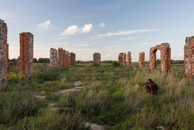 Man relaxing on field against sky