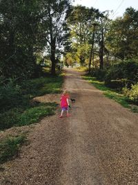 Rear view of girl walking on road