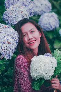 Portrait of smiling young woman with flower bouquet