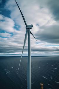 Drone aerial view of windmill in the ocean in a sunny day. ai generated