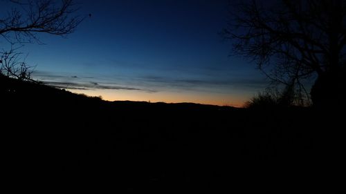 Silhouette landscape against sky at sunset