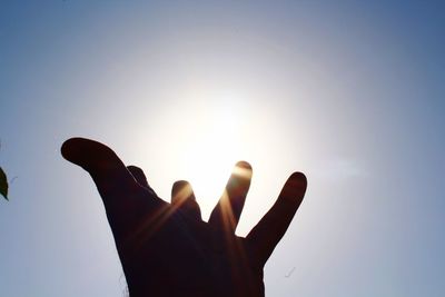 Low angle view of hands against sky