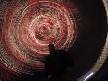 Low angle view of a man against abstract swirls