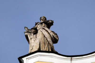 Low angle view of statue against blue sky