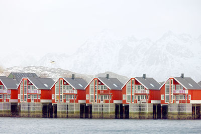 House by lake against sky