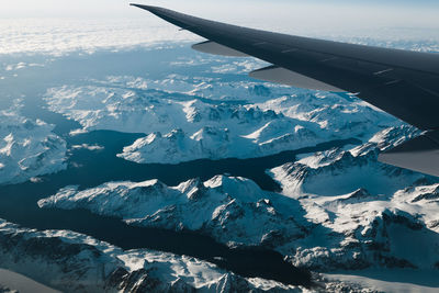 View of aircraft wing against snow covered landscape