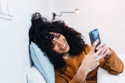 Young woman using mobile phone against white background