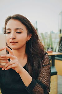 Portrait of young woman using mobile phone