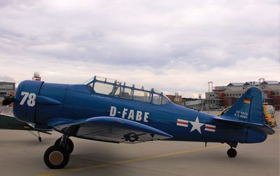 Airplane on airport runway against sky