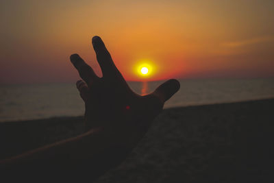 Silhouette of person on beach at sunset