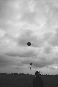 Low angle view of hot air balloons on field against sky